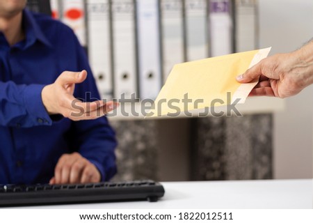 Businessman receiving a padded envelope sitting on a desk at office Royalty-Free Stock Photo #1822012511