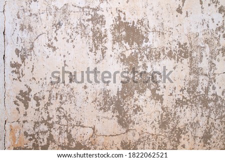 Old cement wall with white peeling paint, grunge background or texture 