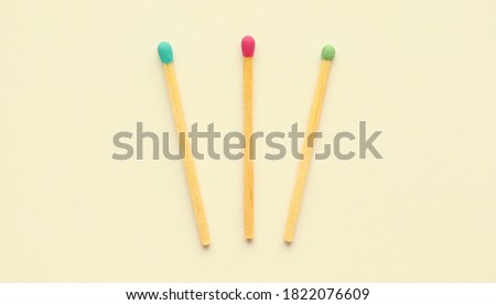 Three multicolor matches isolated on yellow background. Top view. Royalty-Free Stock Photo #1822076609