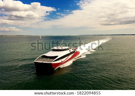 Fast passenger ferry on Southampton Water on a beautiful sunny day with clouds in the blue sky. Space for text. Royalty-Free Stock Photo #1822094855