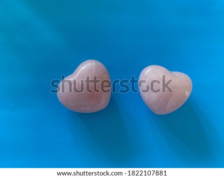 Two pink stone hearts on blue background