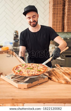 Smiling Baker Packing Tasty Fresh Backed Pizza Into Boxes