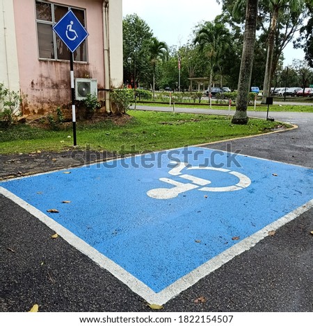 light blue rectangular handicap parking spot on asphalt 