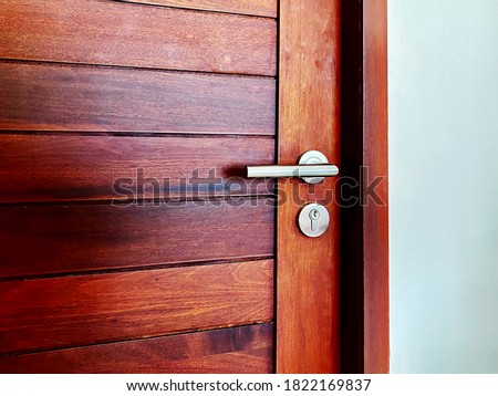 Stainless steel handle and key pad on wooden door was closed in modern house
