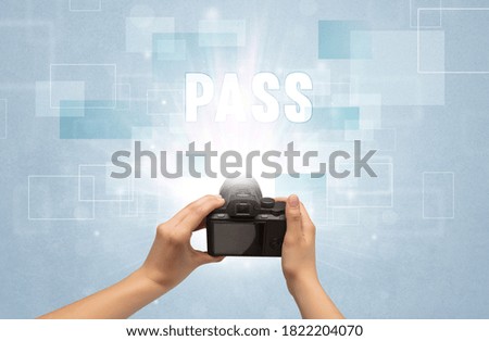 Close-up of a hand holding digital camera with PASS inscription, traveling concept