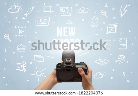 Hand taking picture with digital camera and NEW PHOTO inscription, camera settings concept