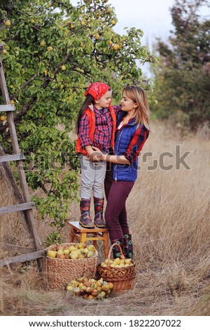 Full length picture of mother and daughter under the pear tree