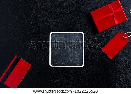 Sale tag, gift box and credit card on a black background.