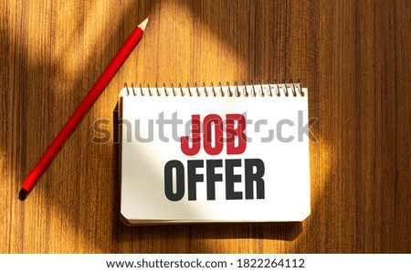 Red pen and notepad with text JOB OFFER in the white background