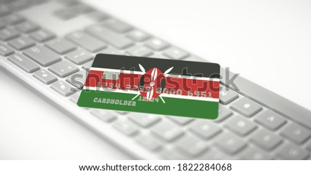 Bank card depicting flag of Kenya on computer keyboard. Fictional numbers