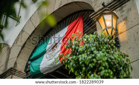 Mexican Flag Hanging Over a Building Arched Entrance