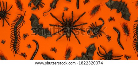 Black Halloween creepy crawly bugs and spiders on orange background Royalty-Free Stock Photo #1822320074