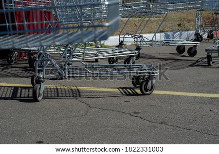 Supermarket Shopping HandCart Cart. Supermarket shopping trolleys in outdoor parking. Empty metal carts on a sunny summer day. 
