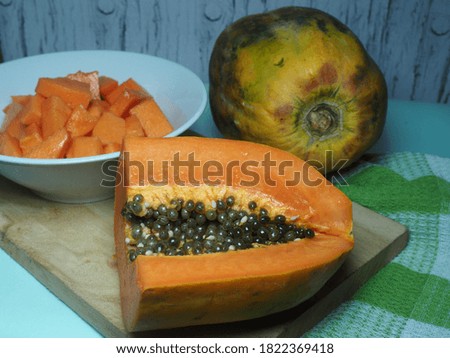 fruit called papayon or milky papaya whole and chopped into pieces and on a plate