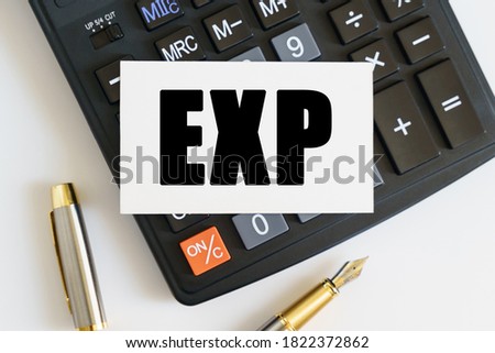 Business and finance concept. On the table there is a pen, a calculator and a business card on which the text is written EXP. EXPORT