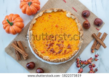 slice of pumpkin pie on plate with pumpkins