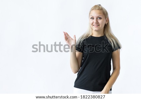 a smiling girl standing and pointing one hand to the side on a white background