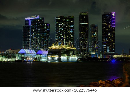 Cruise ship in the Port of Miami at sunset with multiple luxury yachts. Miami night downtown, city Florida. Night view of cruise liners near Miami Port