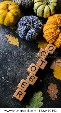 October wooden letters win pumpkins and autumn leaves on dark background. Place for text.