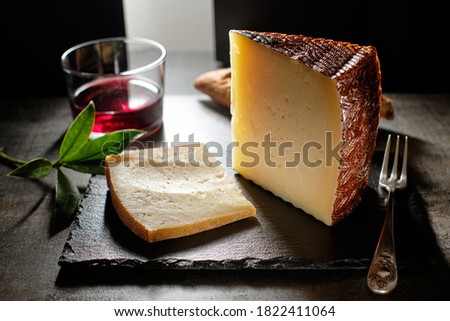 Tasty cured Manchego cheese with glass of wine