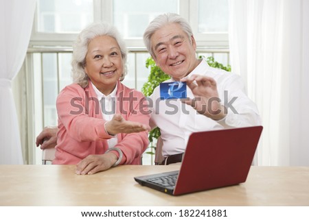	Senior couple holding credit card	