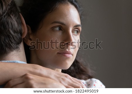 Close up of pensive woman hug man feel skeptical look in distance think of cheating in relationships. Suspicious unfaithful female embrace husband pondering of marriage problems or family troubles. Royalty-Free Stock Photo #1822495019