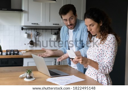 Unhappy young man and woman frustrated by mistake or error when paying bills on computer online. Stunned couple confused by debt calculating family household financial expenditures at home. Royalty-Free Stock Photo #1822495148