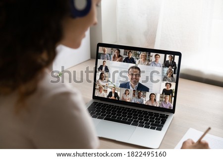 Rear close up view of female employee have webcam digital virtual conference or meeting on laptop with diverse colleagues. Woman talk speak on video call on computer, engaged in online briefing. Royalty-Free Stock Photo #1822495160