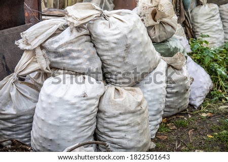 White sacks of crops are piled up.