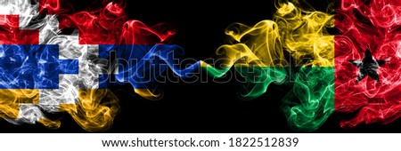 Nagorno-Karabakh, Artsakh vs Guinea Bissau smoky mystic flags placed side by side. Thick colored silky abstract smoke flags