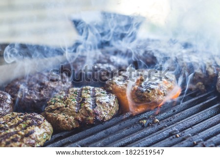 burgers on barbeque with smoke