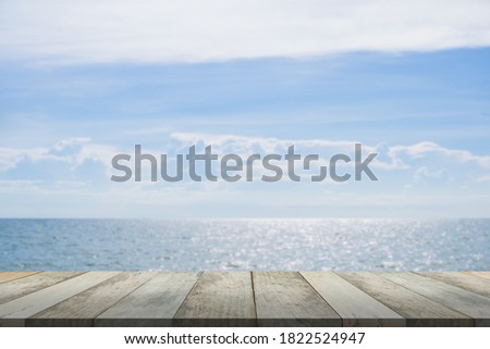 Wood perspective on sea blur image background. Empty top of wooden table.  wood table top on blurred blue sea.