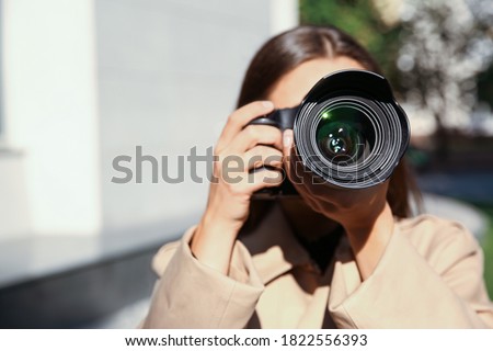 Private detective with camera spying on city street