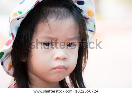  Upset Asian little girl wear hat pattern polka dot colorful. 