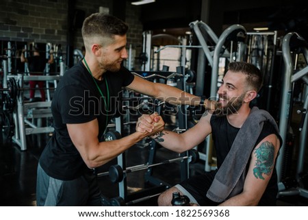 Support from personal trainer in gym Royalty-Free Stock Photo #1822569368