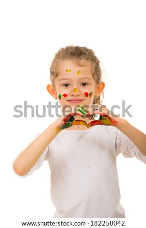 Smiling girl with paints on her face and hands showing heart shape isolated on white background