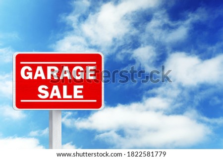 Sign with phrase GARAGE SALE and blue sky