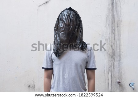 Young Man with a black plastic bag on his head