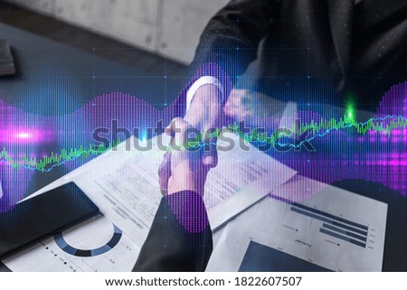 Double exposure of two businesspeople handshake and forex chart hologram drawing background. Concept of capital market analysis. Formal wear.