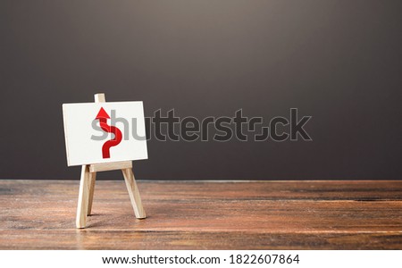 An easel with a red arrow avoiding an obstacle. Deviation from the route. Inevitability and inability to delay the inevitable. Purposefulness and perseverance, confident movement towards assigned goal Royalty-Free Stock Photo #1822607864