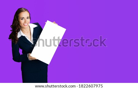 Happy smiling woman in black confident suit and white blouse showing blank signboard. Business and advertising concept. Copy space empty place for some advert ad text. Violet purple color background.	