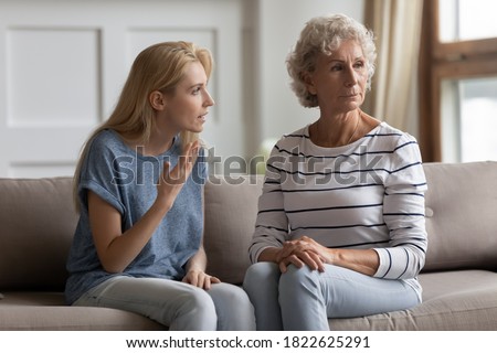 Could you just hear me? Two generations family elderly mother and young daughter quarrelling, having conflict, stressed nervous grown kid trying to explain prove something to mom unwilling to listen Royalty-Free Stock Photo #1822625291