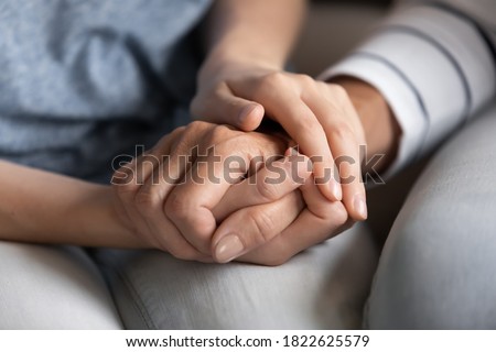 I know you can. Close up of millennial woman grown daughter, grandchild or younger friend holding tight hand of old mother, grandmother, elder relative or colleague helping to overpass life problems Royalty-Free Stock Photo #1822625579
