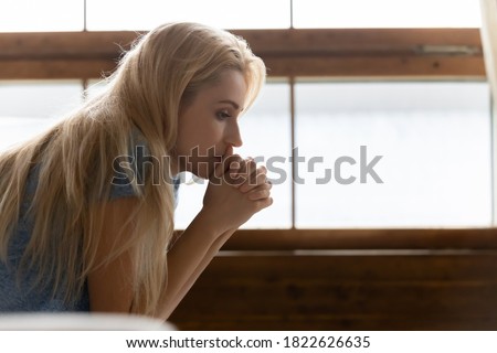 How to deal with it? Side shot of thoughtful pensive sad young female sitting indoors leaning forward propping chin on clasped hands feeling desperate, unhappy, tired, lost, disappointed. Copy space Royalty-Free Stock Photo #1822626635