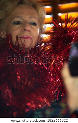 Christmas stocking, woman holding cell phone and making photos.
Winter, beautiful senior woman with red Christmas ornament ,in a rustic cottage. 