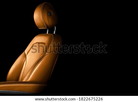 Modern luxury car brown leather interior. Part of orange leather car seat details with white stitching. Interior of prestige car. Comfortable perforated leather seats. Perforated leather.  Royalty-Free Stock Photo #1822675226