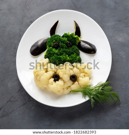 Christmas edible cow with broccoli and cauliflower on a white plate. Proper nutrition concept.