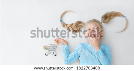 Funny little smiling girl with shopping cart