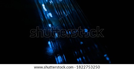 This picture displays colored bottle lights which look like fiber optic cables. The background is black.