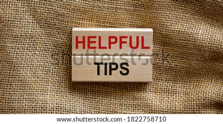 Wooden blocks form the text 'helpful tips' on beautiful canvas background. Business concept.